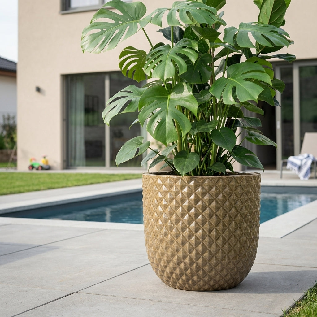 Detail na velký keramický květináč Mars Broušený bronz. Ručně vyráběný glazovaný květináč z terakoty na moderní rodinné terase u bazénu.