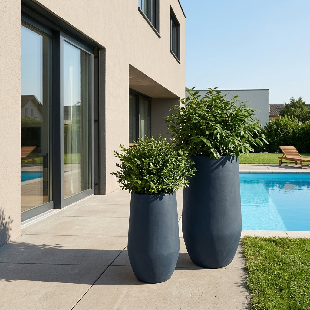 Detail tmavě šedého betonového květináče Zenith XXL (40 x 80 cm) s keřem na moderní terase s bazénem.